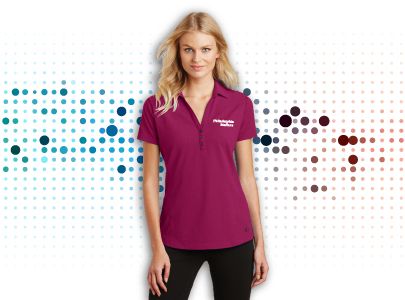 Woman wearing burgundy, button down, collared polo shirt embroidered with Philadelphia Staffers logo